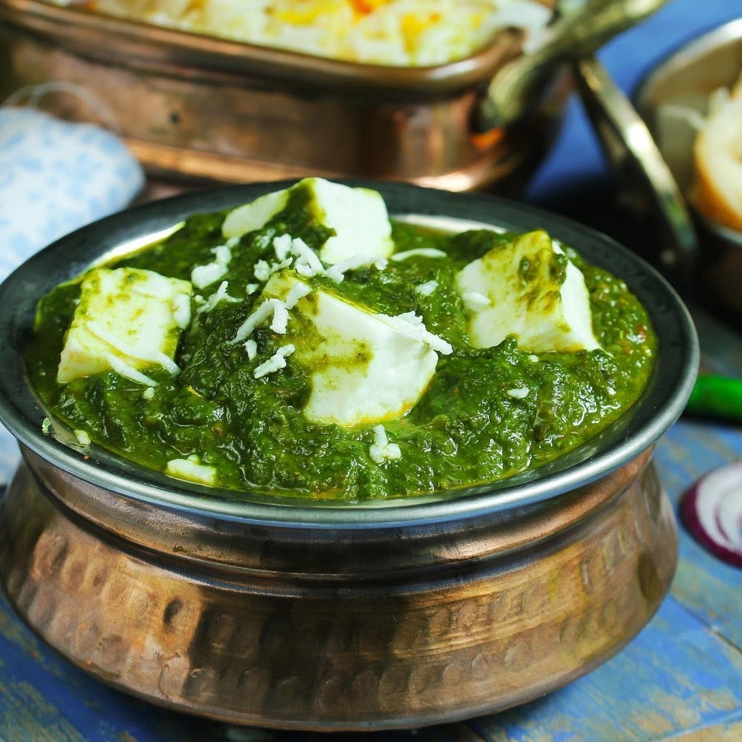 Palak paneer in a copper serving bowl